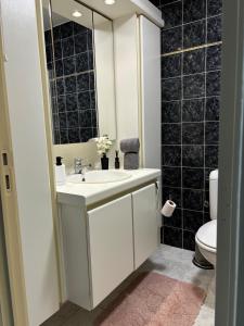 a bathroom with a sink and a mirror at Studio Sia - Lichtrijke studio met balkon met zijzeezicht in hartje de Panne in De Panne +13 photos