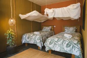 a bedroom with two beds and a hanging canopy at AguaMar Vichayito in Vichayito
