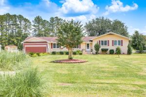 a house with a tree in the middle of a yard at Moncks Corner Home about 4 Mi to Lake Moultrie! in Moncks Corner