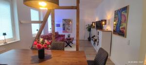 un tavolo da pranzo con un vaso di fiori sopra di DIE HOTELALTERNATIVE DELUXE APP erste Etage mit 2 Schlafzimmer Haus 63 a Solingen