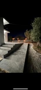a walkway at night with a building and lights at Ammoudia Summer House in Skiathos