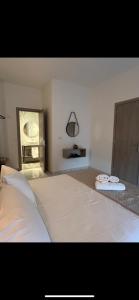 a bedroom with a large bed with two towels on it at Ammoudia Summer House in Skiathos