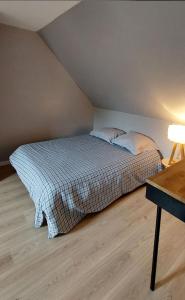 ein Bett mit zwei Kissen in einem Zimmer in der Unterkunft Maison mer et campagne in Pluvigner