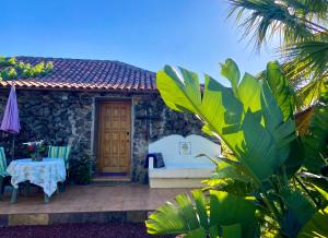 a house with a table and a chair and a table and a table at Finca Tenerife - Traumblick, tropischer Garten, viel Platz & Ruhe in Icod de los Vinos