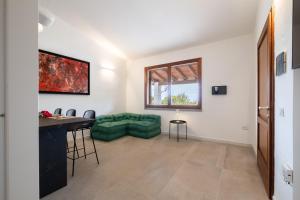 a living room with a green couch and a table at Residence Abba Urci in Tertenìa