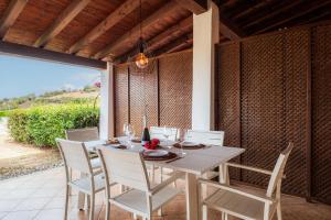 a dining table and chairs on a patio at Residence Abba Urci in Tertenìa