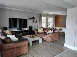 a living room with two couches and a tv at Champers with a view in Cape Town