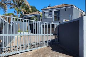 a white fence in front of a house at Champers with a view in Cape Town