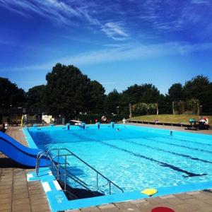 a large blue swimming pool with a ramp in it at Fridfullt sommarhus mitt på Österlen nära Simrishamn, Tomelilla och Ystad in Gärsnäs