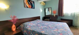 a bedroom with a bed with a blue wall at Hotel Bijou in Burgas