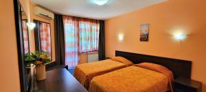 a hotel room with two beds and a window at Hotel Bijou in Burgas +5 photos