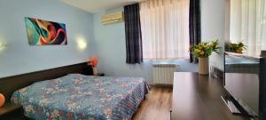 a bedroom with a bed and a table in it at Hotel Bijou in Burgas