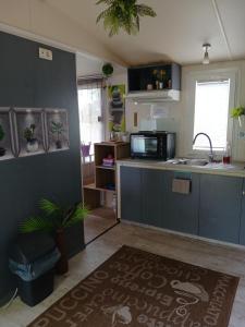 a kitchen with a sink and a counter top at Kék-Fehér Mobilház in Zsombó +15 photos