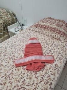 ein Bett mit einem roten Handtuch darüber in der Unterkunft Club Meridional Carneiros in Tamandaré