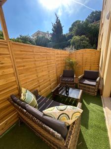 a patio with two wicker chairs and a table at Residence "A Torbia" , 5 appartements de 2 à 6 personnes in La Turbie