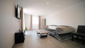 salon z kanapą i krzesłem w obiekcie Agréable Villa pour 8 personnes w mieście Pont-du-Château