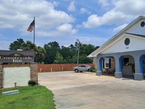 un edificio con una bandera americana en un estacionamiento en Countryside Inn, en Harleyville