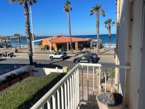 een balkon met uitzicht op de oceaan en palmbomen bij la plage in Six-Fours-les-Plages