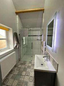 a bathroom with a sink and a shower at Pretty Garden Cottage in Tollerton