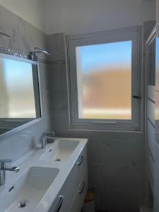 een witte badkamer met een wastafel en een raam bij la plage in Six-Fours-les-Plages +9 foto's