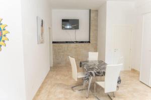 a dining room with a table and white chairs at villa corinzia 2 in Noto
