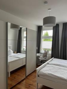 a bedroom with two beds and a mirror at Apartment Ute - Gemütliche und moderne Ferienwohnung in der Innenstadt in Pasewalk