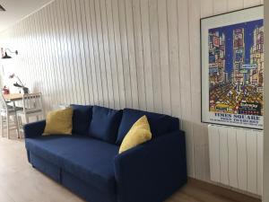 a blue couch with yellow pillows in a living room at Coniferas in Santander