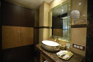 a bathroom with a sink and a mirror at Hotel ACME in Kolkata