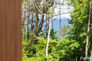 a view of the ocean through the trees at Prestige 103 - z widokiem na morze - BASEN, sauna, jacuzzi w cenie pobytu! - Easy - Rent Apartments in Pobierowo