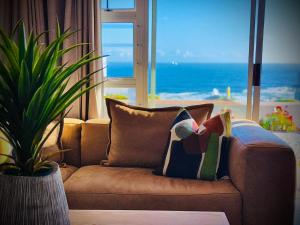 a couch with a pillow on it in a living room at LazyYzer in Yzerfontein