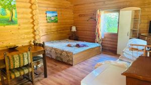 a bedroom with a bed in a log cabin at Audrones sodyba in Šventoji