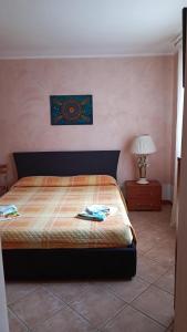 a bedroom with a bed and a table with a lamp at APPARTAMENTO PAMELA b&b in Grado