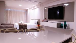 a white room with a bed and a tv at Beach Class Internacional - Studio Vista Mar em Boa Viagem por Yolo in Recife