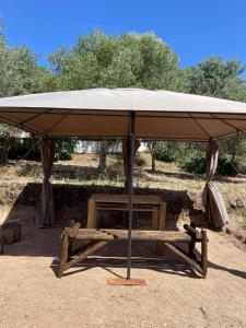 Un paraguas grande en un soporte en un campo en Casa das Romãs, en Salvada