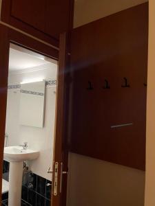 a bathroom door with a sink and a mirror at Maria's central apartment in Xanthi +21 photos