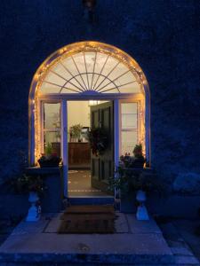an entrance to a house with an arch with lights at Lisglassock House in Longford