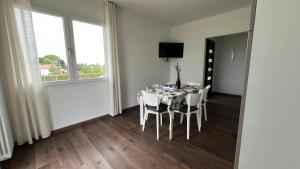 a dining room with a table with white chairs at Casa Grazia in Eraclea