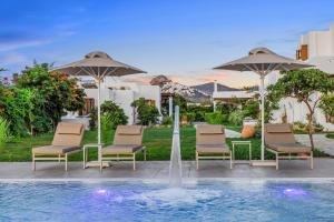 una piscina con sillas, sombrillas y una fuente en Anemonisia Skyrian Living, en Skiros