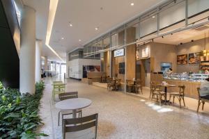 a cafeteria with tables and chairs and a counter at HLB_1508, com vaga de estacionamento, mercado 24h ao lado e a 11km do Aeroporto Internacional de Guarulhos in Guarulhos