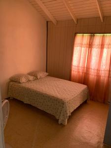 a bedroom with two beds and a window at Chocolate apartment in English Harbour Town