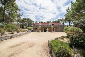 an image of a house with a large driveway at Résidence Les Grands Pins - maeva Home - 2 Pièces 5 Personnes Sélection MAE-1769 in Maubuisson +6 photos