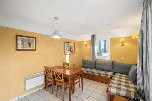 a living room with a couch and a table at Résidence Les Grands Pins - maeva Home - 2 Pièces 5 Personnes Sélection MAE-1769 in Maubuisson