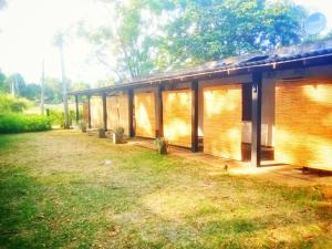 a small building with windows and a grass yard at Fair View Bungalow in Kataragama