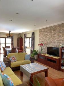 a living room with a couch and a tv at Villa Reencuentro Mojácar Playa in Mojácar +42 photos
