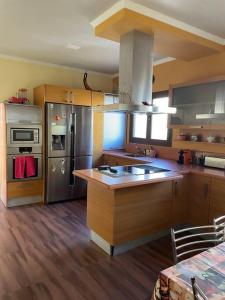 a kitchen with stainless steel appliances and wooden floors at Villa Reencuentro Mojácar Playa in Mojácar