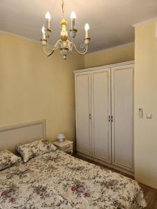 a bedroom with a bed and a chandelier at Apartments Anna on the Sunny beach in Sunny Beach +18 photos