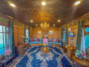 a living room with a blue couch and a chandelier at Peacock Houseboats in Srinagar