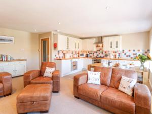 a living room with a couch and chairs and a kitchen at Crab Corner in Wells next the Sea