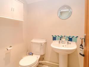 a bathroom with a white toilet and a sink at Crab Corner in Wells next the Sea +18 photos