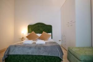 um quarto com uma cama grande com cabeceira verde em Fororomano Luxury em Roma